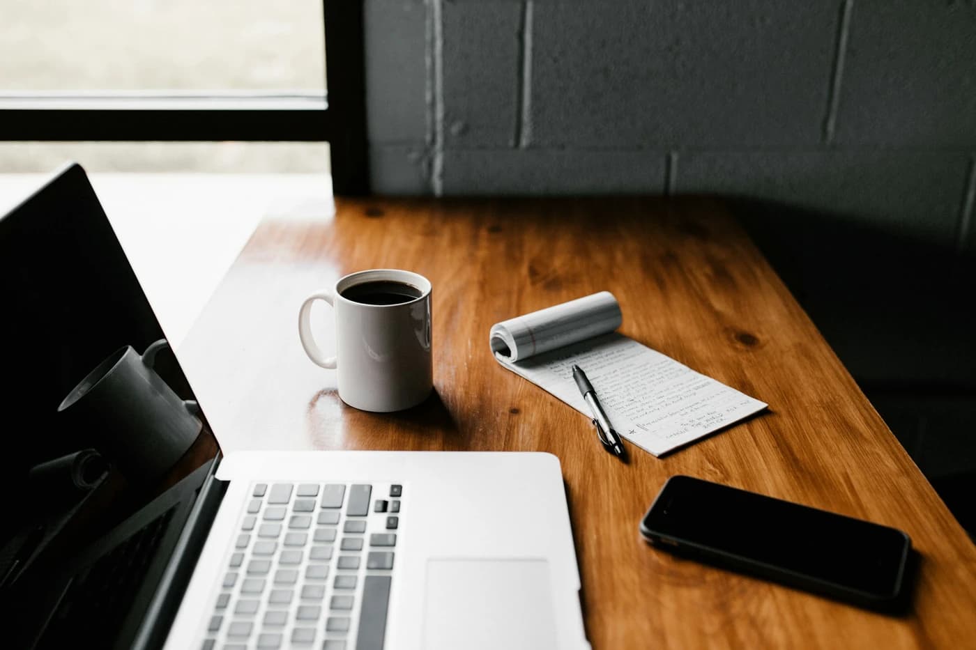 Laptop and coffee on a wooden desk